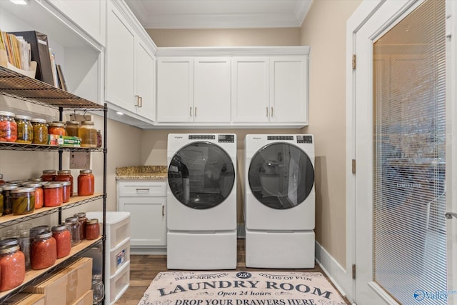 washroom featuring washer and dryer, crown molding, cabinets, and wood-type flooring