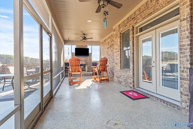 sunroom featuring ceiling fan and french doors