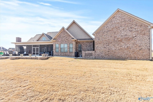 view of front of property with a patio area, a sunroom, and a front lawn