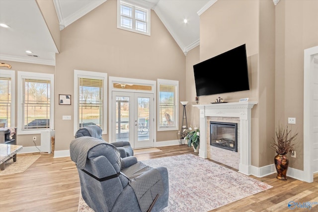 living room with crown molding, french doors, high vaulted ceiling, and light wood-type flooring