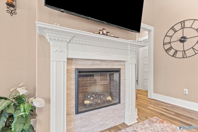 interior details featuring hardwood / wood-style floors and a tiled fireplace