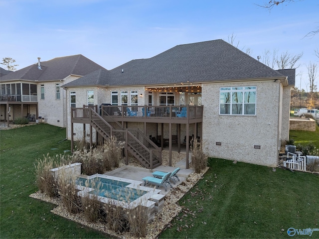 back of house with a lawn, a patio area, a deck, and a jacuzzi