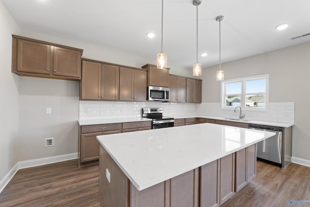 kitchen featuring a sink, visible vents, appliances with stainless steel finishes, decorative backsplash, and dark wood-style floors