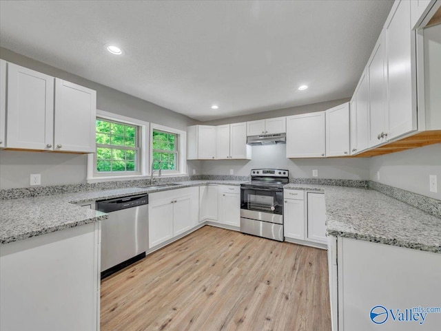 1492 County Road 314, Town Creek, AL 35672 - kitchen featuring stainless steel appliances, light wood-type flooring, recessed lighting, white cabinetry, and light stone counters