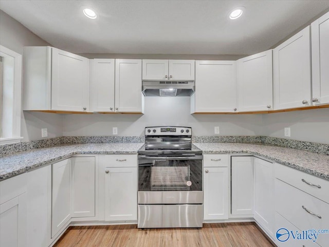 1492 County Road 314, Town Creek, AL 35672 - kitchen with stainless steel electric stove, under cabinet range hood, light wood finished floors, white cabinets, and recessed lighting