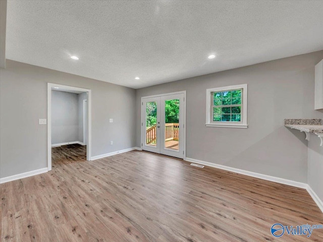 1492 County Road 314, Town Creek, AL 35672 - unfurnished living room featuring light wood-style flooring, a textured ceiling, baseboards, and recessed lighting