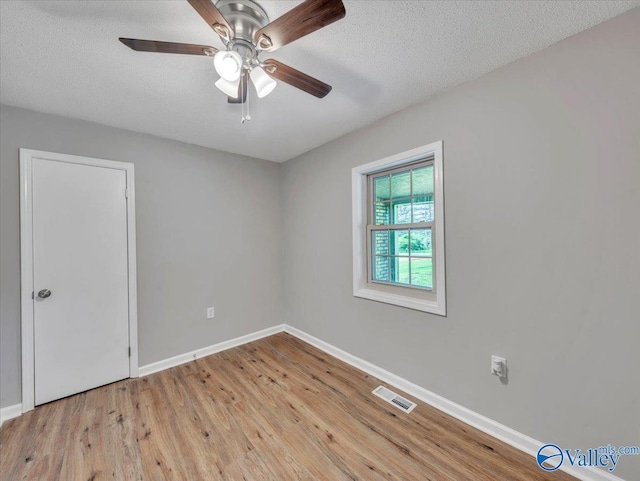 1492 County Road 314, Town Creek, AL 35672 - unfurnished room featuring baseboards, light wood-type flooring, a ceiling fan, and a textured ceiling