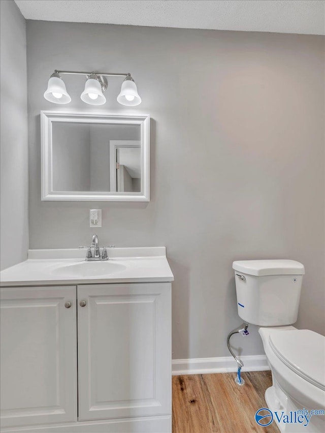 1492 County Road 314, Town Creek, AL 35672 - half bathroom with wood finished floors, toilet, vanity, and baseboards