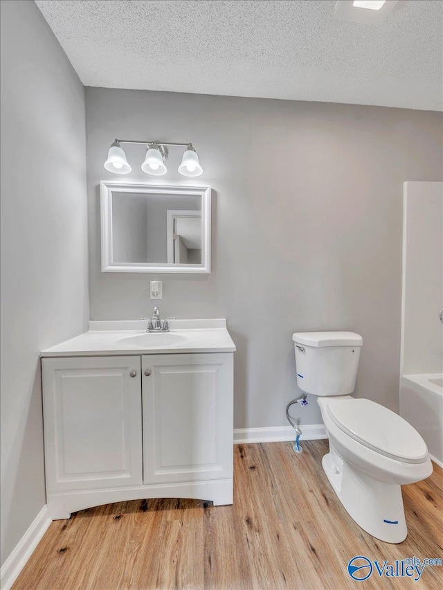 1492 County Road 314, Town Creek, AL 35672 - full bathroom featuring toilet, wood finished floors, vanity, baseboards, and a bath