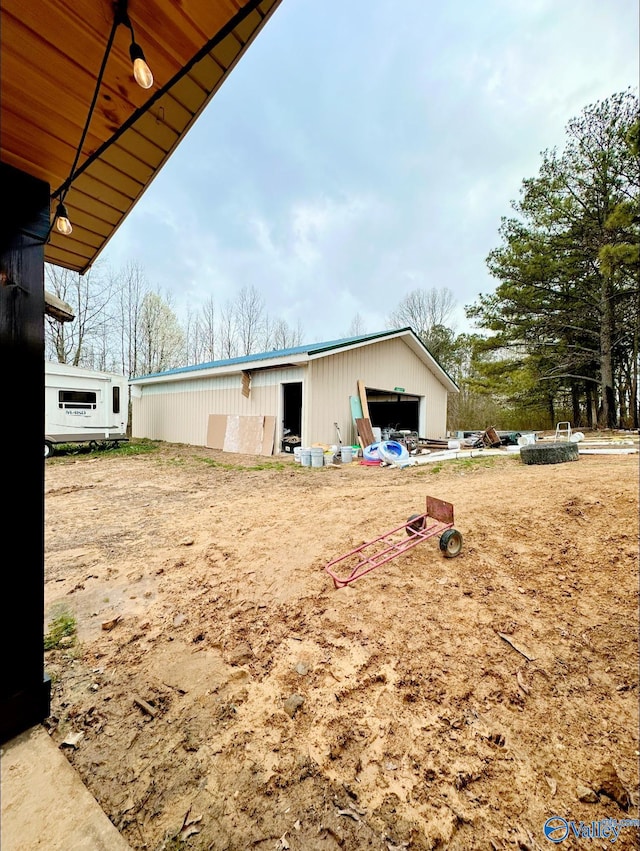 view of yard featuring a garage and an outbuilding