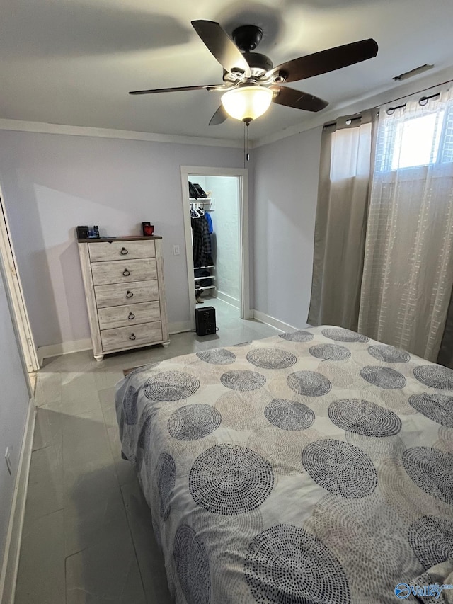 bedroom with ceiling fan, a walk in closet, and crown molding