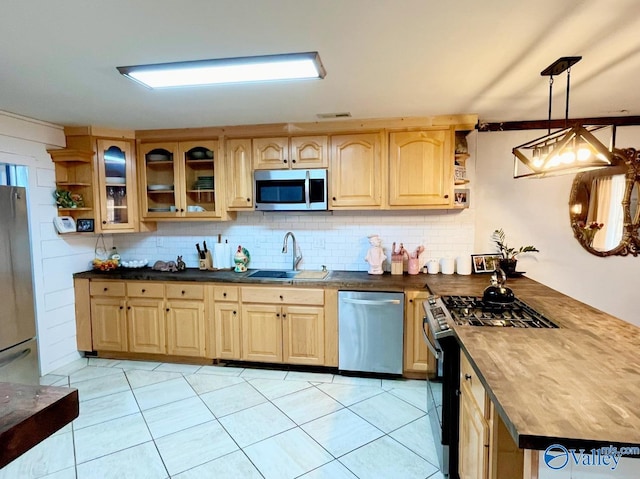 kitchen with sink, wooden counters, decorative light fixtures, stainless steel appliances, and decorative backsplash