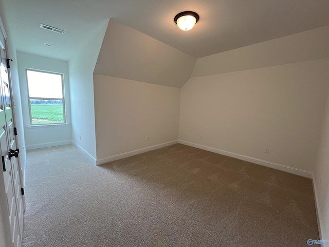 bonus room with lofted ceiling and carpet flooring