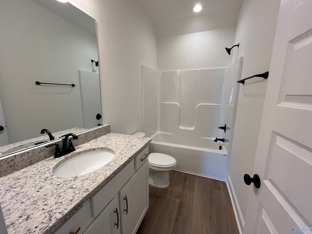 full bathroom featuring shower / bath combination, vanity, hardwood / wood-style floors, and toilet