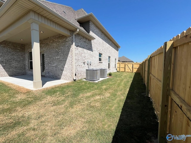 view of side of home with a yard, central AC, and a patio area