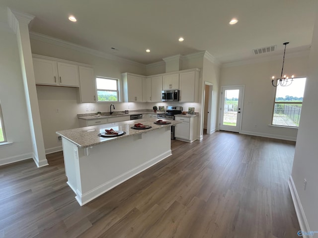 kitchen featuring white cabinetry, sink, a center island, light stone counters, and stainless steel appliances