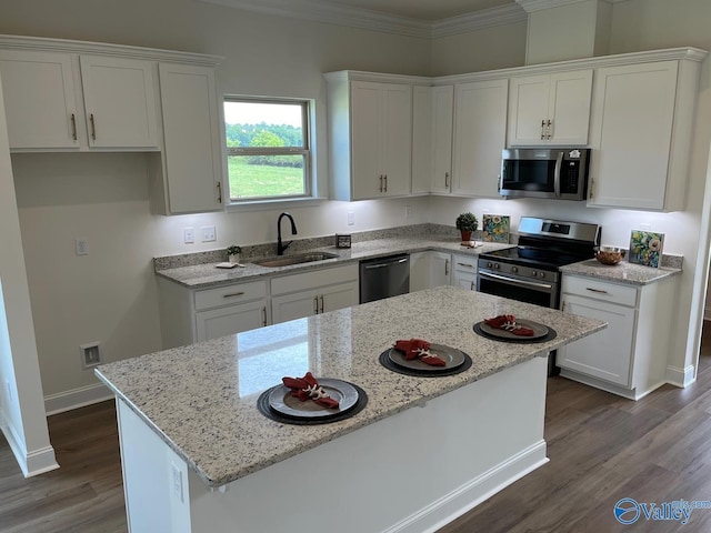 kitchen featuring white cabinetry, sink, a kitchen island, and appliances with stainless steel finishes