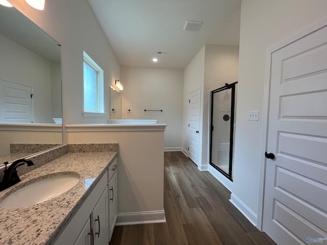 bathroom featuring a shower, wood-type flooring, and vanity