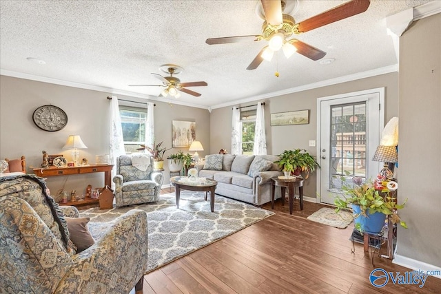 living room with ornamental molding, hardwood / wood-style floors, a textured ceiling, and ceiling fan