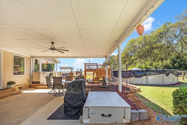 view of patio / terrace featuring ceiling fan and a covered pool