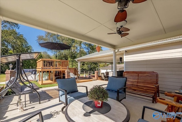 view of patio / terrace featuring a wooden deck, ceiling fan, and an outdoor living space