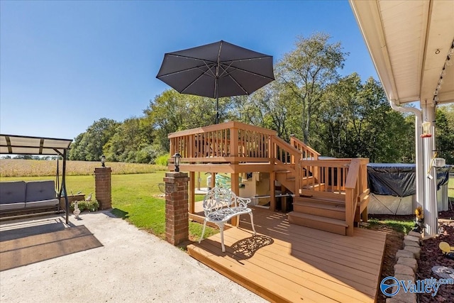 wooden terrace featuring a patio, a jacuzzi, and a lawn