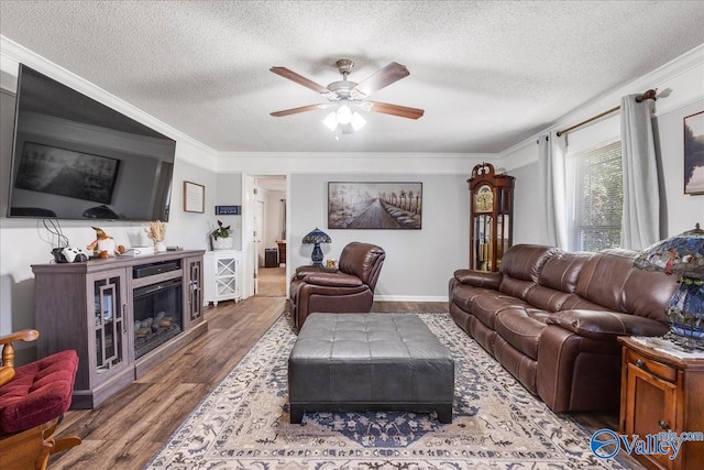 living room with crown molding, dark hardwood / wood-style floors, a textured ceiling, and ceiling fan