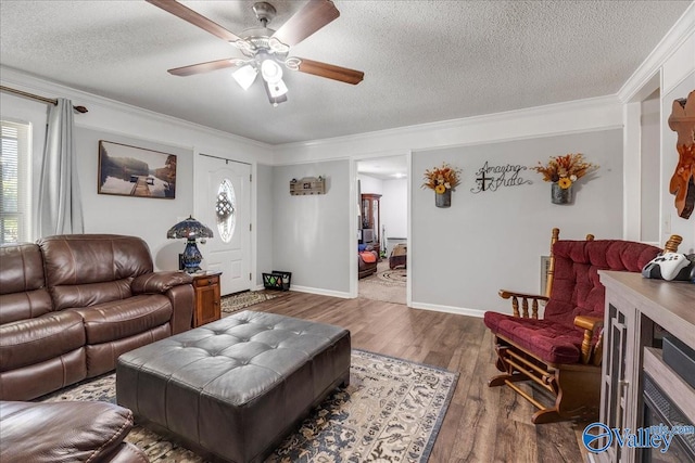 living room with ornamental molding, a textured ceiling, hardwood / wood-style flooring, and ceiling fan