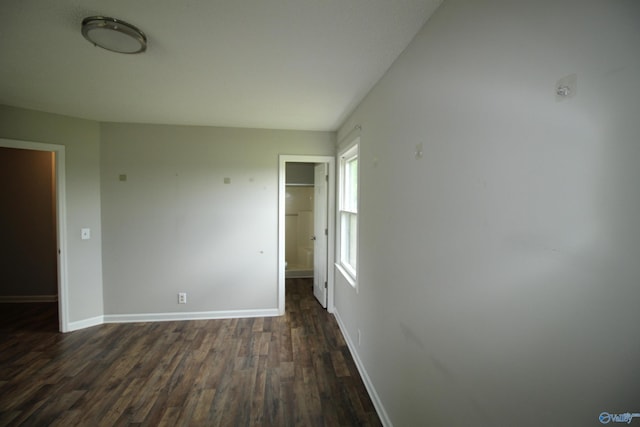 115 Kathleen Dr, Hazel Green, AL 35750 - unfurnished bedroom with dark wood-style flooring, baseboards, a closet, and a walk in closet