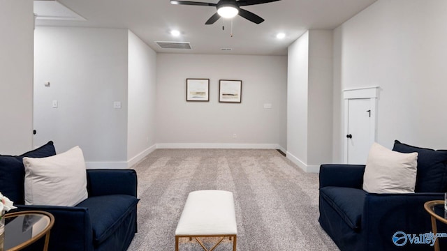 sitting room with ceiling fan and carpet