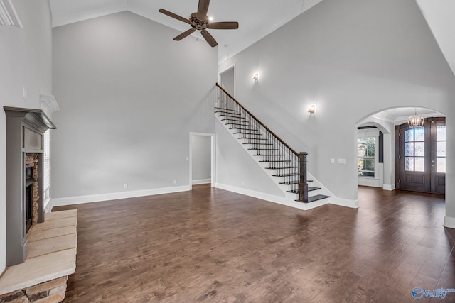 unfurnished living room with ceiling fan, high vaulted ceiling, ornamental molding, and dark hardwood / wood-style floors