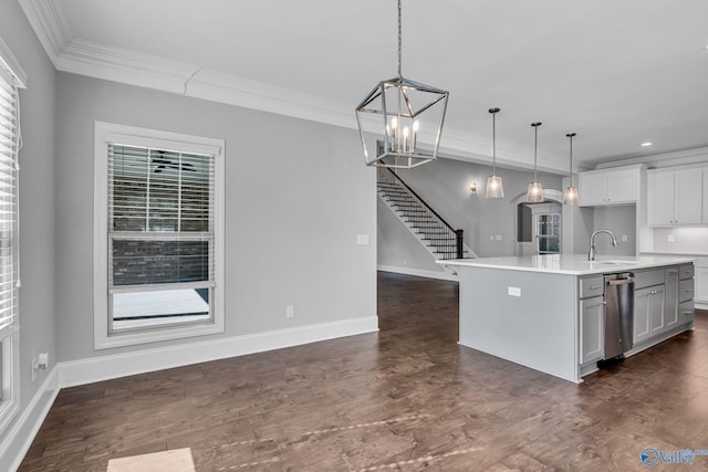 kitchen with dark wood-type flooring, a center island with sink, sink, crown molding, and pendant lighting