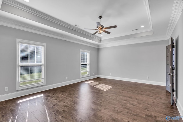 unfurnished room with ceiling fan, a tray ceiling, ornamental molding, and dark hardwood / wood-style flooring