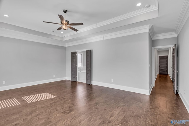 spare room featuring ceiling fan, a tray ceiling, ornamental molding, and dark hardwood / wood-style flooring