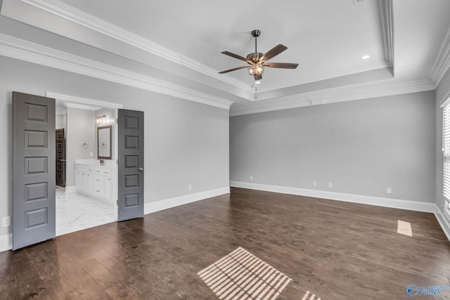 interior space with ceiling fan, crown molding, a raised ceiling, and hardwood / wood-style floors