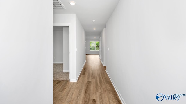 corridor with baseboards, visible vents, wood finished floors, and recessed lighting