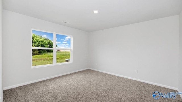 carpeted spare room featuring baseboards