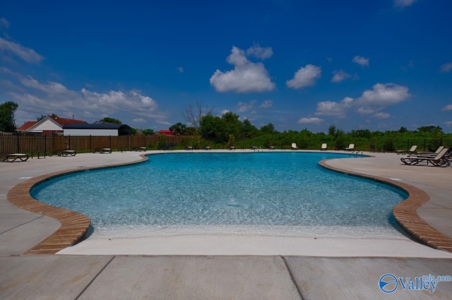 pool featuring fence and a patio