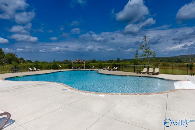 community pool featuring a gazebo, a patio area, and fence