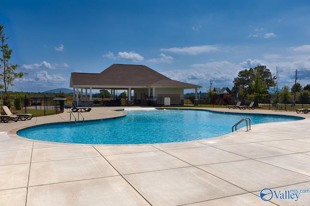 community pool with a patio and fence