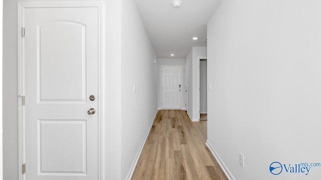 hallway featuring recessed lighting, baseboards, and light wood-type flooring