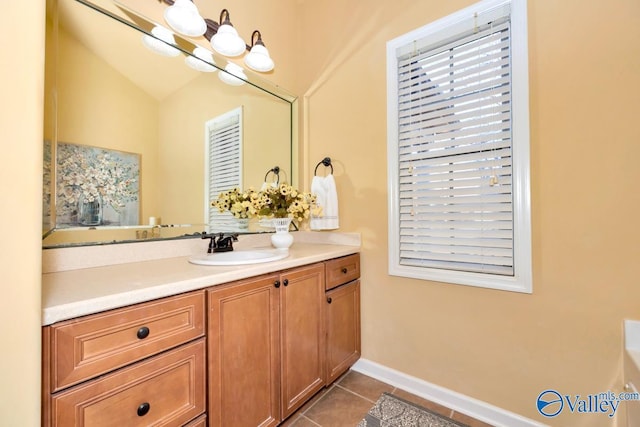 bathroom with tile patterned flooring, baseboards, a notable chandelier, and vanity