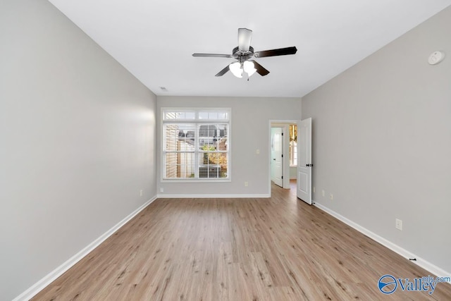 empty room featuring a ceiling fan, light wood-type flooring, and baseboards