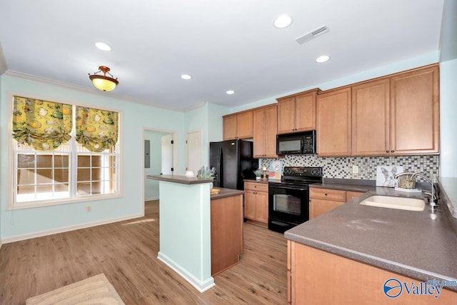 kitchen featuring a center island, tasteful backsplash, dark countertops, a sink, and black appliances