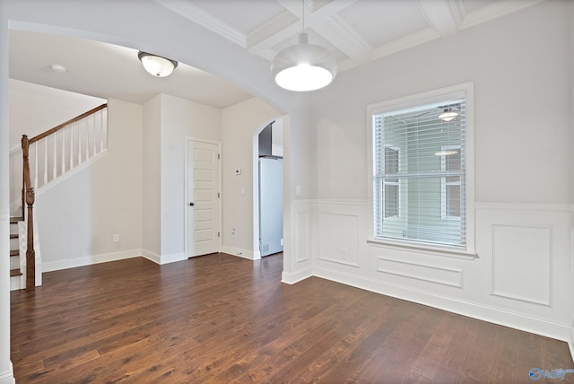 empty room featuring dark hardwood / wood-style flooring, coffered ceiling, crown molding, and beamed ceiling