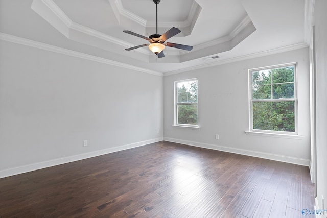 unfurnished room featuring ceiling fan, dark hardwood / wood-style floors, a tray ceiling, and ornamental molding