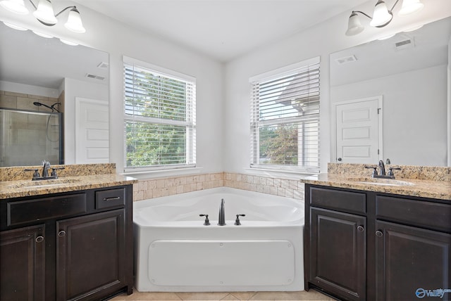 bathroom with shower with separate bathtub, a healthy amount of sunlight, and vanity