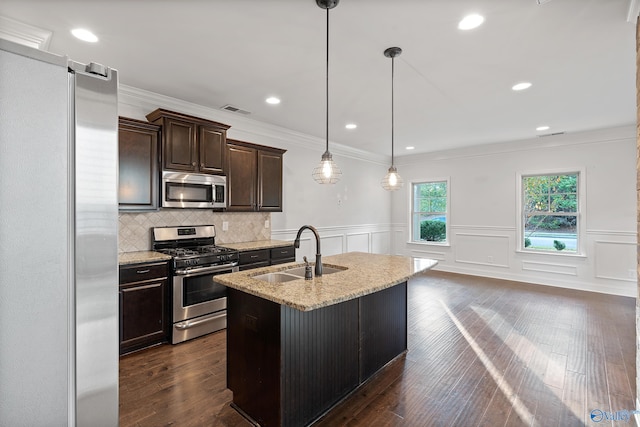 kitchen with dark hardwood / wood-style flooring, pendant lighting, sink, and stainless steel appliances