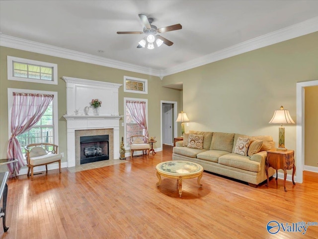 7515 Park Trace Ln SE, Owens Cross Roads, AL 35763 - living room featuring ceiling fan, light wood-type flooring, crown molding, and a tiled fireplace