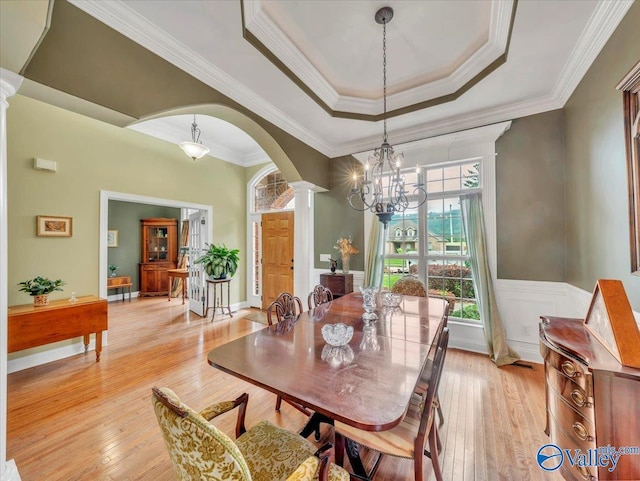 7515 Park Trace Ln SE, Owens Cross Roads, AL 35763 - dining space with decorative columns, arched walkways, light wood finished floors, crown molding, and a tray ceiling